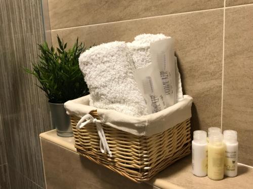 a basket with towels and other products on a shelf in a bathroom at Apartments Maestral in Tivat
