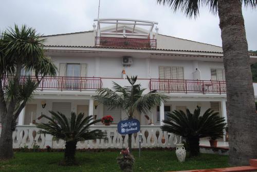 a large white building with palm trees in front of it at SANTA VENERE Apartments "PARCHEGGIO interno MOTO-AUTO" Ricarica auto Elettriche in Tropea