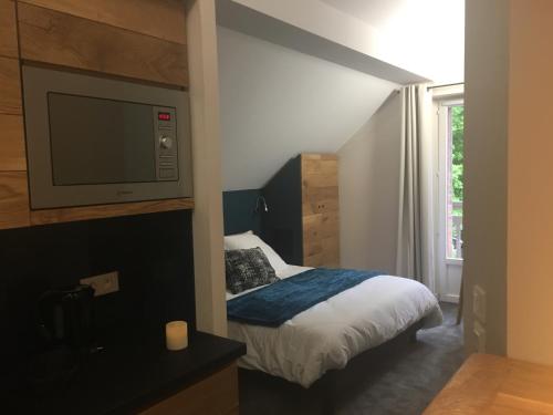a small bedroom with a bed and a tv at Appart'Hotel Aiguille Verte & Spa in Chamonix-Mont-Blanc