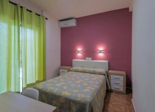 アルムニェーカルにあるHostal Rocamarの紫の壁のベッドルーム1室(ベッド1台付)