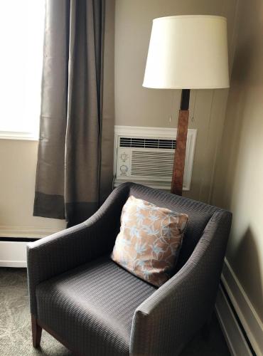 a couch with a pillow and a lamp in a room at Seasons Inn Halifax in Halifax