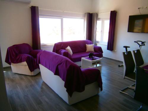 a living room with a purple couch and chairs at Apartment Willy in Komiža