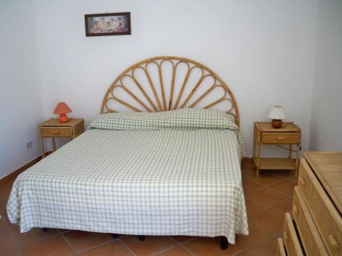 una camera da letto con un letto con una coperta a scacchi e due tavoli di L'Isolana Case Vacanza Luna 2 a Ponza