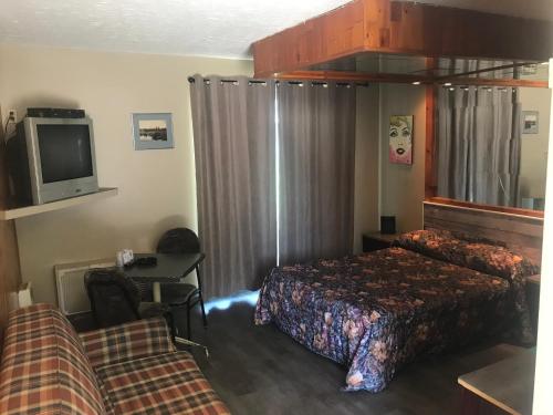 a hotel room with two beds and a tv at Motel la Siesta de Gascon in Terrebonne