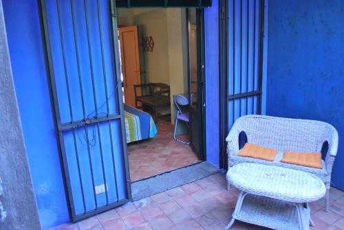 a chair with an orange pillow sitting next to a door at Case Vacanze Fossanave in Santa Tecla