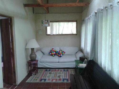 a living room with a white couch and a window at Aconchego das Montanhas in Alagoa