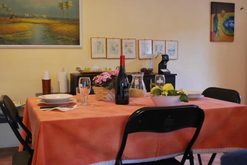 a table with a orange table cloth and a bottle of wine at Case Vacanze Fossanave in Santa Tecla