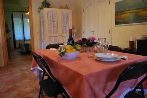 a table with a bottle of wine and a bowl of fruit at Case Vacanze Fossanave in Santa Tecla