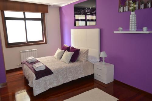 um quarto roxo com uma cama e uma janela em Apartamento Plaza Perillana em Ponteareas