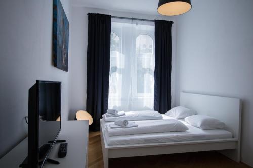 Schlafzimmer mit einem Bett und einem Fenster in der Unterkunft Porzellangarten Apartment I contactless Check-In in Wien