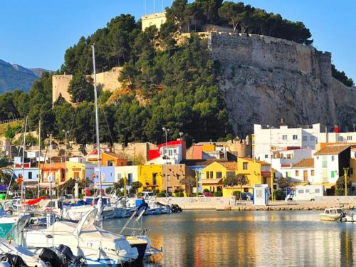 un grupo de barcos atracados en un puerto con una colina en Apartment Playa Sol 2, en Denia