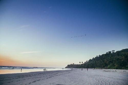 a group of people standing on a beach at Lua Villas in Santa Teresa Beach