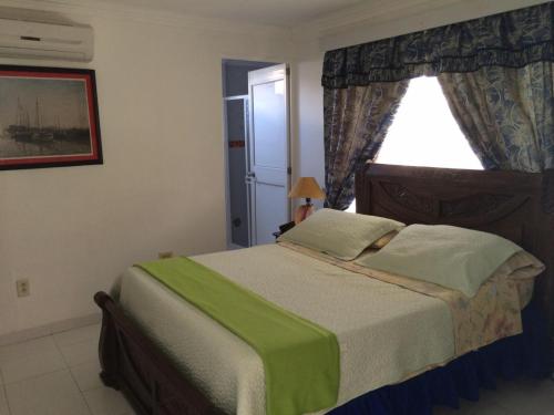 a bedroom with a large bed with a window at Cli´s Place Posada Nativa in San Andrés