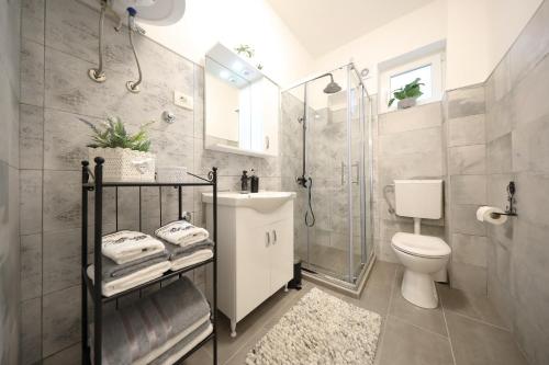 y baño con ducha, aseo y lavamanos. en Studio apartman Sendy, en Zadar