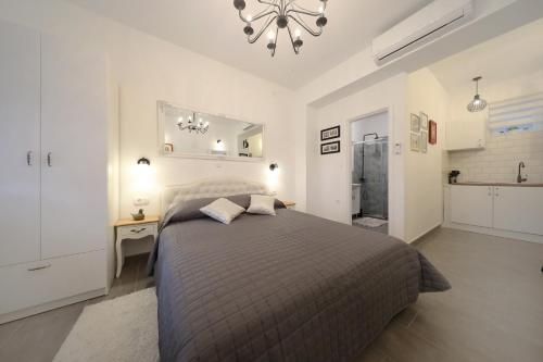 Un dormitorio con una cama grande y una lámpara de araña. en Studio apartman Sendy, en Zadar