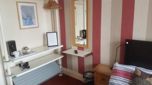a hotel room with a mirror and a bed at Angel Guesthouse in Tiverton