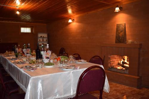 a dining room with a table and a fireplace at Family Hotel Lago & Wine Cellar in Lagodekhi
