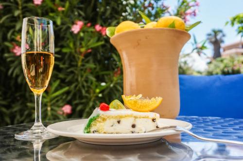 a piece of cake on a plate next to a glass of wine at Albergo Ristorante Saverino in Valderice