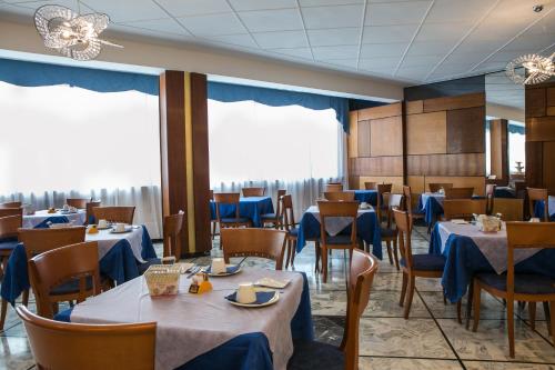a dining room with tables and chairs with blue table cloth at Hotel Ariston in Imperia