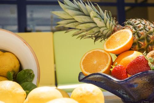 a bowl of fruit with a pineapple and oranges at Albergo Ristorante Saverino in Valderice