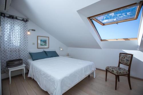 - une chambre avec un lit, une chaise et une fenêtre dans l'établissement The Architects Home, à Dubrovnik