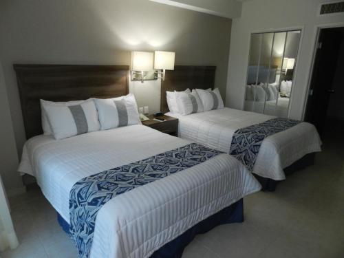 a hotel room with two beds and a mirror at Hotel Villa Florida Veracruz in Veracruz