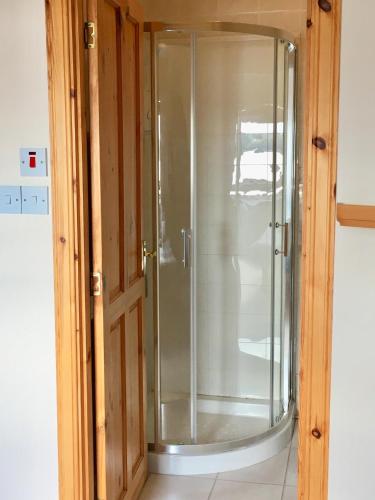a glass shower in the corner of a room at White Cottage B&B in North Kessock