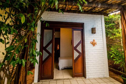 a door leading into a room with a bed at Villas de Tibau in Pipa