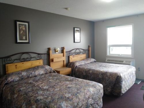 a hotel room with two beds and a window at Aries Motel in Edson
