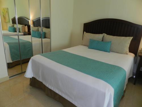 a bedroom with a large bed and a mirror at Astur Hotel & Residence in Veracruz
