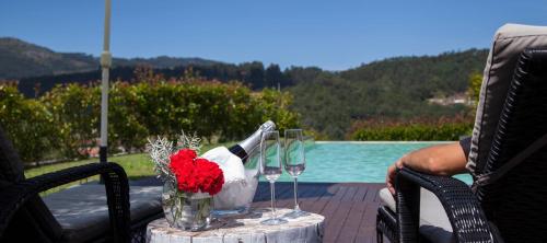 a table with wine glasses and a bouquet of flowers at Quinta Da Mouta in Vieira do Minho