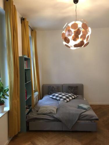 a bedroom with a bed and a chandelier at Enjoy Leipzig in Leipzig