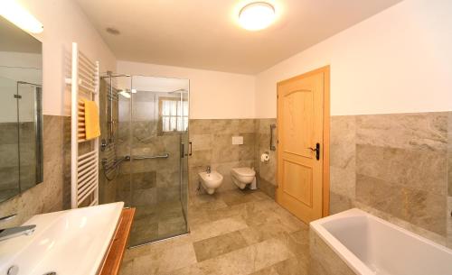 a bathroom with a tub and a shower and a toilet at Masitterhof in Bressanone
