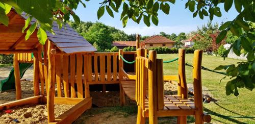 a wooden playground with a slide in a yard at Ubytovanie LISKA in Radava