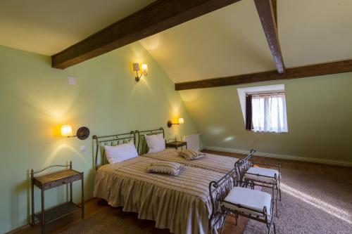 1 dormitorio con 1 cama con 2 sillas y una ventana en Unglerus Guesthouse, en Biertan