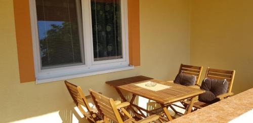 a dining room with a table and chairs and a window at Ubytovanie LISKA in Radava