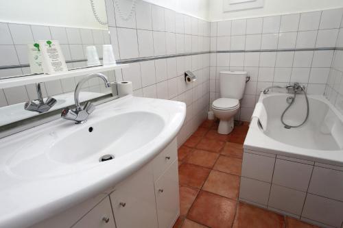 een badkamer met een wastafel, een bad en een toilet bij Hôtel Des Nacres in Ventiseri