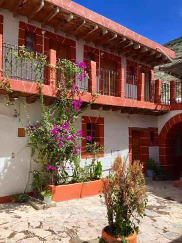 a building with flowers on the side of it at Hotel Hacienda Encantada in Real de Catorce