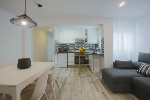 Una cocina y una sala de estar con una mesa y un sofá. en Valencia Beach Marina, en Valencia