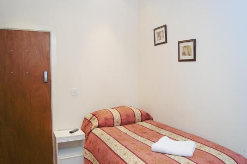 a bedroom with a bed with a towel on it at The Dharma Lodge in Enfield