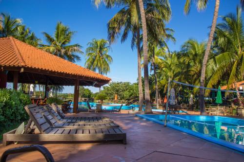 ein Resort mit einem Pool und Palmen in der Unterkunft Eco Resort Foz do Marinheiro in São João do Marinheiro