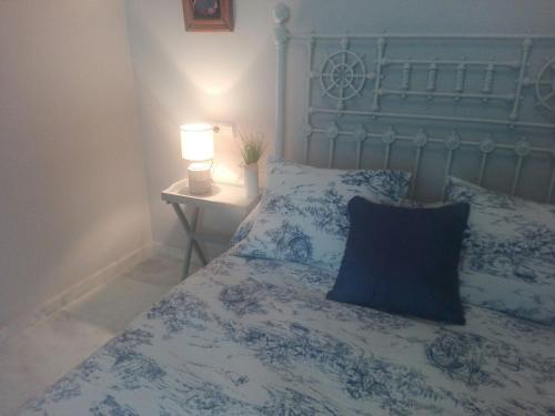 a blue and white bed with a lamp on a table at Charming Villadarias M. Palace apartment in Antequera