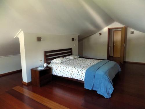 a bedroom with a bed and a wooden floor at Silveira by the Sea in Angra do Heroísmo