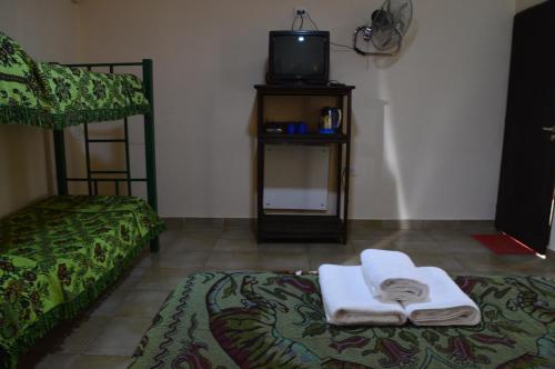 a room with two beds and a tv on a table at El Refugio in Yala
