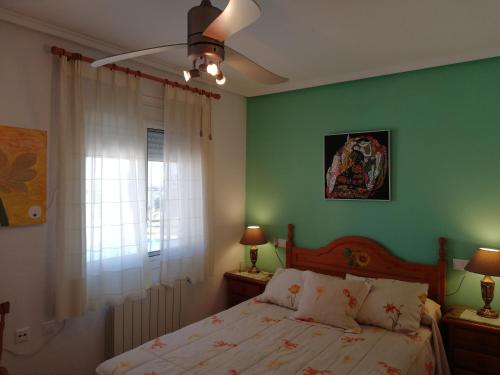 サンタ・ポラにあるBungalow Junto A La Piscina, Gran Alacantの緑の壁、ベッド付きのベッドルーム1室