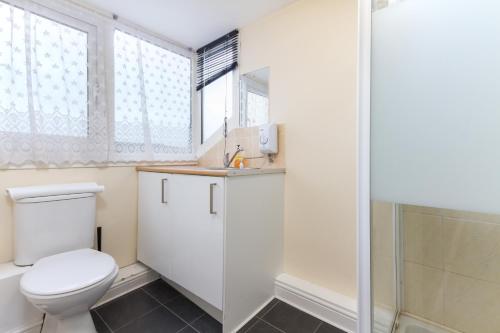 a bathroom with a toilet and a shower at Brecks Hotel in Blackpool