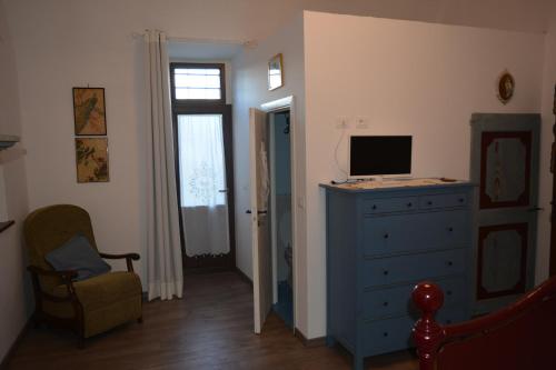 ein Schlafzimmer mit einer blauen Kommode und einem TV darauf in der Unterkunft La Mongolfiera Del Platonio in Farnese