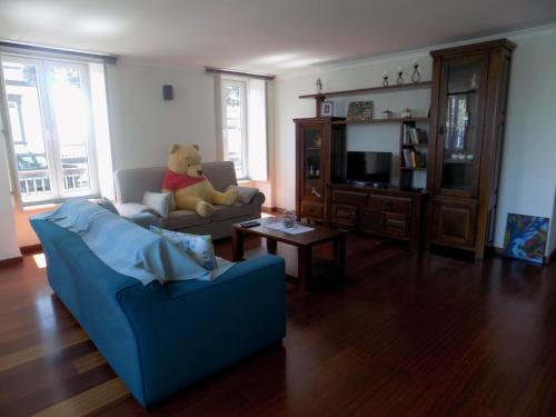 a teddy bear sitting on a couch in a living room at Silveira by the Sea in Angra do Heroísmo
