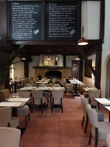 a restaurant with tables and chairs and a fireplace at Les Pins Blancs en Provence in Le Muy