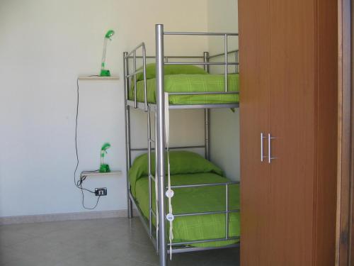 a room with two bunk beds with green sheets at Annalisa Apartments 250 dal mare in San Vito lo Capo